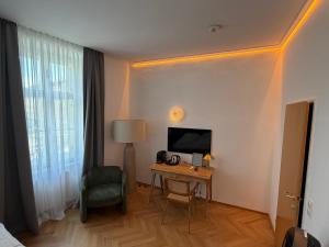 ein Hotelzimmer mit Fernseher und Tisch mit Stuhl in der Unterkunft Kolbeck Rooms in Wien + 38 Fotos