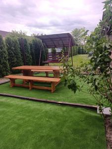 a picnic table and a gazebo in a yard at Гостьовий будинок з банею in Bohuslav