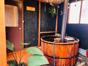 a large wooden barrel in a room with a plant at Cabañas y tinajas in Ancud