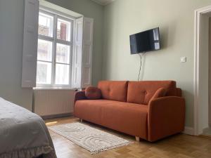 a living room with a couch and a flat screen tv at Patak & Stone apartman in Szentendre