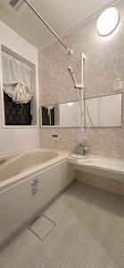 a bathroom with a tub and a sink at guesthouse嵐 in Osaka
