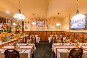 a restaurant with tables and chairs in a room at Hotel Victoria in Pilsen