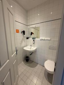 ein Badezimmer mit Toilette und Waschbecken in der Unterkunft Kolbeck Rooms in Wien