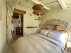a bedroom with a white bed with a stone wall at Monte Pino in Pergola +91 photos