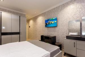 a bedroom with a bed and a tv on a wall at Şimal Hotel in Quba +18 photos