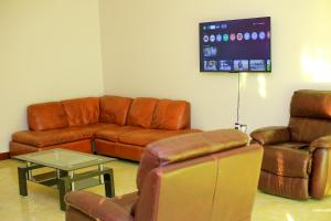 a living room with leather furniture and a screen at standalone in Fort Portal