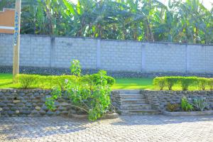 a stone retaining wall with stairs and a bush at standalone in Fort Portal