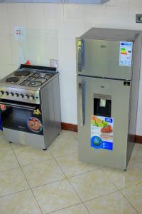 a refrigerator and a stove in a kitchen at standalone in Fort Portal