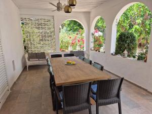 a dining room with a wooden table and chairs at Villa Dunes 350m from the sandy beach in Kalogria