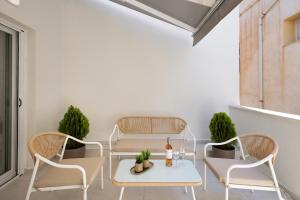 a patio with chairs and a table with a bottle of wine at Alexander Seaview Haven in Ermoupoli
