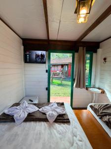 a bedroom with a bed with a tv on the wall at Linha Nova Glamping in Gramado