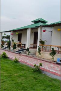 a building with tables and a green umbrella at Ak Green View Beach Resorts in Chīrāla