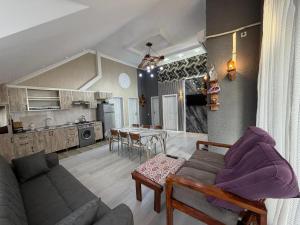 a living room and kitchen with a couch and a table at Gabala Home in Gabala