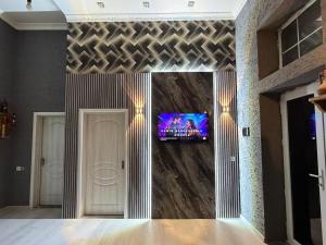 a living room with a tv on a wall at Gabala Home in Gabala