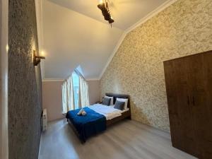 a bedroom with a bed with blue sheets and a window at Gabala Home in Gabala