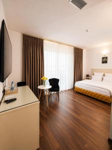 a hotel room with a bed and a desk and a tv at Wald Hotel Lagodekhi in Lagodekhi