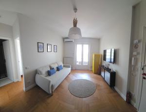 a living room with a white couch and blue pillows at Blu Marine Loano -Terrazza Vista Mare- in Loano