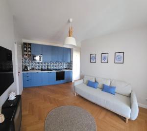 a living room with a couch and blue cabinets at Blu Marine Loano -Terrazza Vista Mare- in Loano