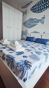 a bedroom with a bed with a blue and white comforter at Blu Marine Loano -Terrazza Vista Mare- in Loano