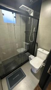 a bathroom with a toilet and a glass shower at Forest in Domingos Martins