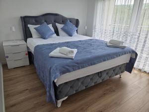 ein Schlafzimmer mit einem großen Bett, auf dem zwei Handtücher liegen in der Unterkunft Villa Alisa - Luxury Riverside Escape in Bihać + 23 Fotos