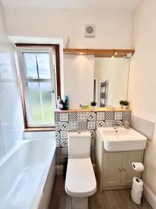 a bathroom with a toilet and a sink and a tub at The Castle Front Nest in Inverness +23 photos
