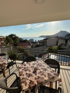 a balcony with tables and chairs and a view of the ocean at Apartmani Becic in Sutomore