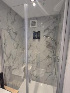a shower in a bathroom with a marble wall at Cozy & Elegant Central Apartments in Hannover