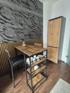 a table and a chair in a room with a wall at Cozy & Elegant Central Apartments in Hannover