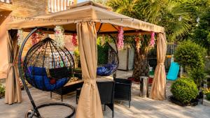 a gazebo with chairs and a bird cage at Hotel Jacob in Ureki