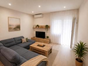 a living room with a blue couch and a tv at Apartment Ivan in Marina