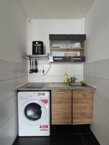 a small kitchen with a washing machine and a sink at Cozy & Elegant Central Apartments in Hannover +2 photos
