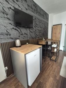 a kitchen with a table and a television on a wall at Cozy & Elegant Central Apartments in Hannover
