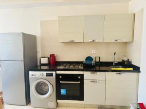 a kitchen with a refrigerator and a washing machine at Islane Holiday Studio with pool&balcony in Agadir