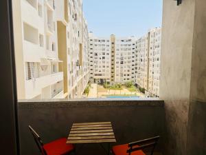 a table and chairs on a balcony with buildings at Islane Holiday Studio with pool&balcony in Agadir