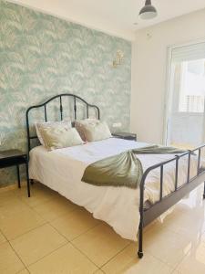 a bedroom with a bed and a green wall at Islane Holiday Studio with pool&balcony in Agadir