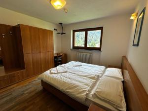 a bedroom with a large bed with a window at Hotel du Foyer Brusson in Brusson