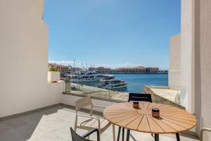 a balcony with a table and chairs and a view of a harbor at Syranna in Ermoupoli