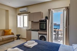 a room with a bed and a kitchen with a balcony at Syranna in Ermoupoli