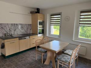 a kitchen with a wooden table and a table and chairs at Ferienwohnung am Gothewanderweg in Schwarza