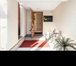 a entrance to a building with a door and a rug at nonnon house in Osaka