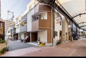 a building with a car parked in front of it at nonnon house in Osaka