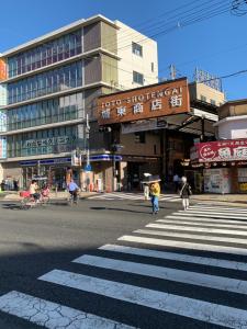 a busy city street with people crossing a crosswalk at nonnon house in Osaka