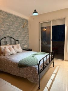 a bedroom with a bed and a sliding glass door at Islane Holiday Studio with pool&balcony in Agadir