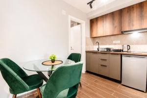a kitchen and dining room with a table and green chairs at Apartments Ilija in Ohrid