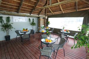 a patio with tables and chairs with fruit on them at Ferry Palms Guest Lodge in Arcadia