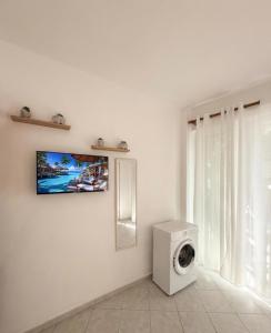 a white washing machine in a room with a window at FLISVOs 70 m από την θάλασσα in Erateini