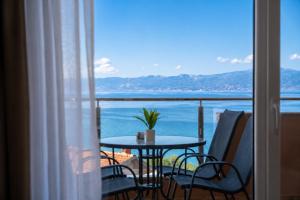 a balcony with a table and chairs and a view of the ocean at Apartments Ilija in Ohrid