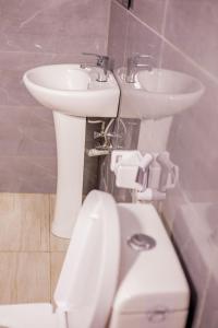 a white sink and a toilet in a bathroom at Olivia Green Lodge in Arusha +56 photos