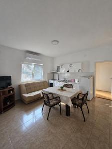 a living room with a table and chairs and a couch at Nin Apartman Free Parking in Kaluđerica